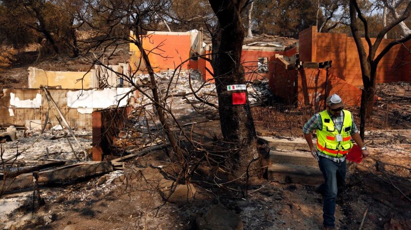 An engineering manager with the County of Napa Planning, Building and Environmental Services Department red tags a home destroyed in the Atlas fire in Napa, Calif. on October 13, 2017.