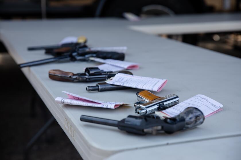 Fully processed guns that will later be destroyed sit on a table during a gun buyback exchange at Encanto Southern Baptist Church on Saturday, June 5. Unwanted pistols and rifles were exchanged for $100 and $200 gift cards.