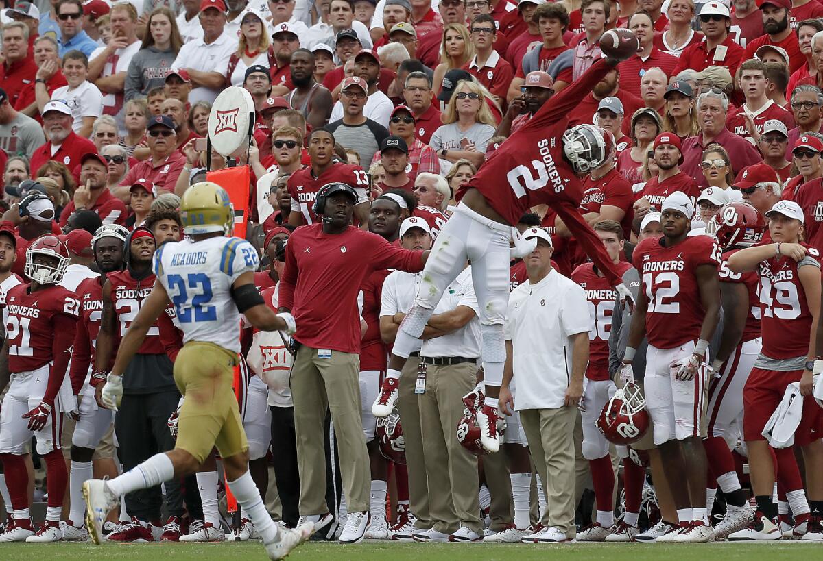 Oklahoma receiver CeeDee Lamb makes a spectacular catch but can't stay in bounds against Bruins cornerback Nate Meadors in the third quarter of their game.