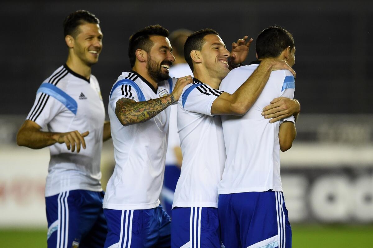 Argentina teammates Martin Demichelis, Gonzalo Higuain and Maxi Rodriguez share a joke with Angel di Maria during a training session ahead of the World Cup final.