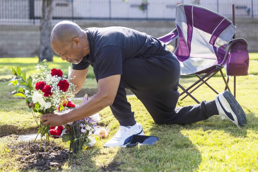 Inglewood, CA - July 18: Montise Bulley, father of Justin Bulley, puts flowers at his grave in Inglewood, CA on Thursday, July 18, 2024. (Zoe Cranfill / Los Angeles Times)