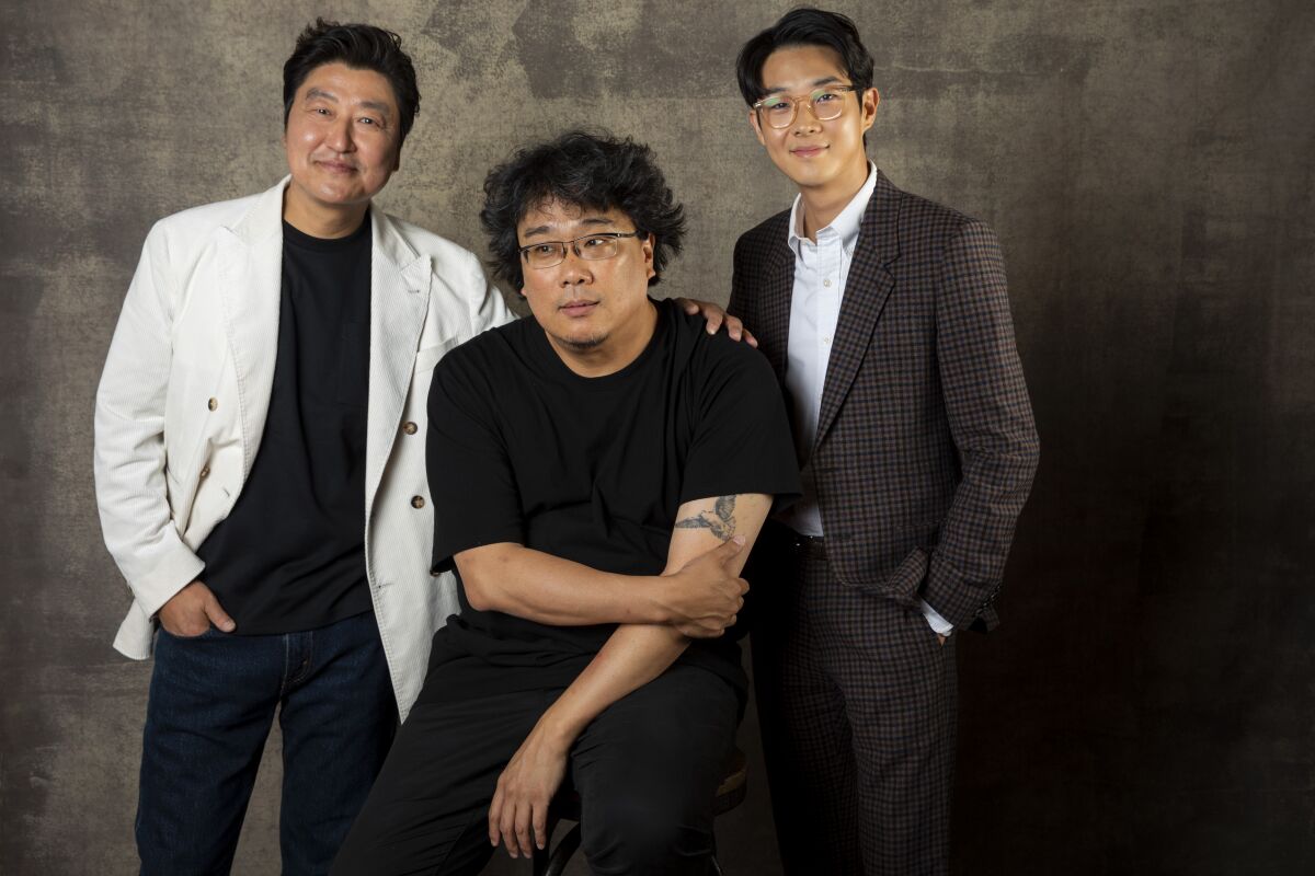 Actor Song Kang Ho, left, director Bong Joon Ho and actor Choi Woo Shik, from the film "Parasite," in the L.A. Times photo studio at the Toronto International Film Festival on Sept. 7.