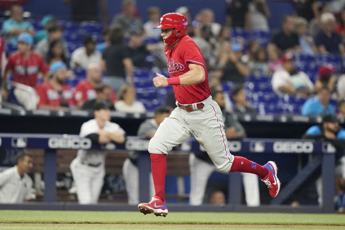 Philadelphia Phillies' Rhys Hoskins runs to score on a sacrifice fly hit by Alec Bohm during the first inning of a baseball game against the Miami Marlins, Saturday, April 16, 2022, in Miami. (AP Photo/Lynne Sladky)