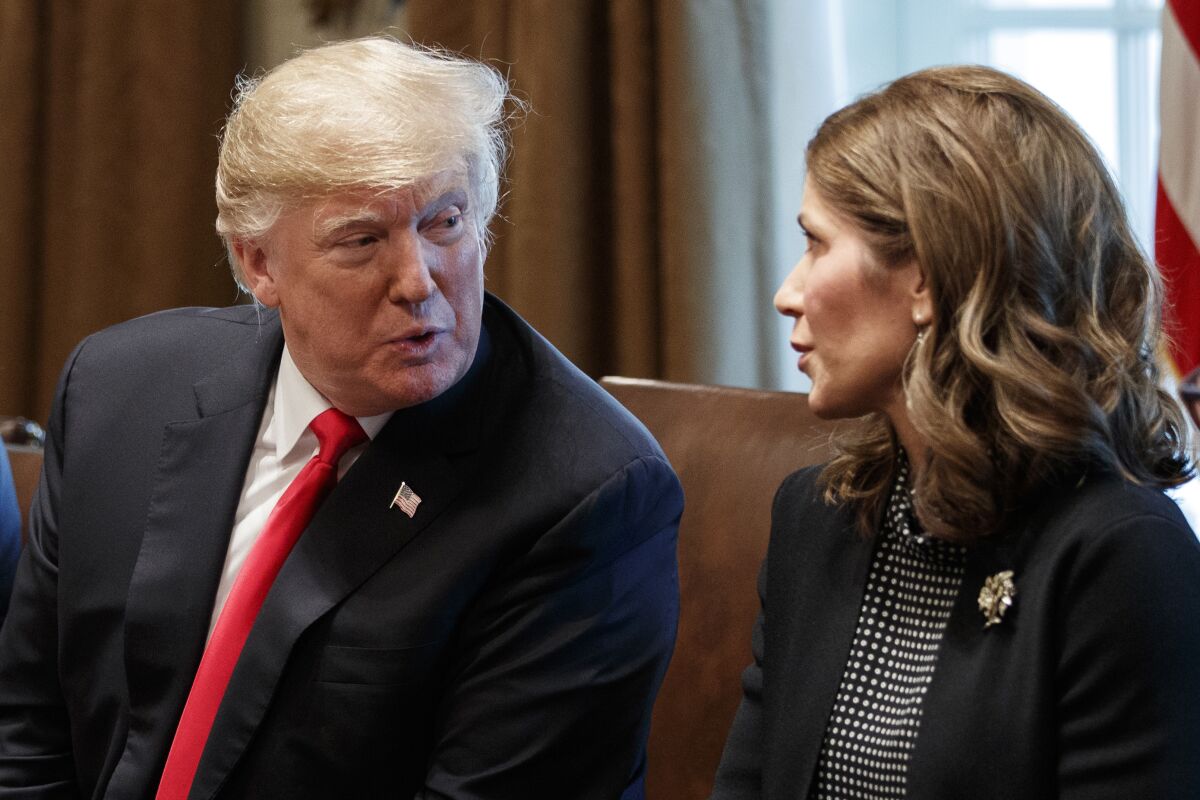FILE - In this Dec. 12, 2018 file photo, President Donald Trump speaks to then-Gov.-elect Kristi Noem, R-S.D., during a meeting at White House in Washington. At the governor's request, the South Dakota Department of Tourism aired a Fox News ad narrated by Gov. Noem that premiered alongside her speech at the Republican National Convention. The 30-second spot, which cost taxpayers $819,000, advertises the state as a place open for visitors despite the coronavirus pandemic. (AP Photo/Evan Vucci File)