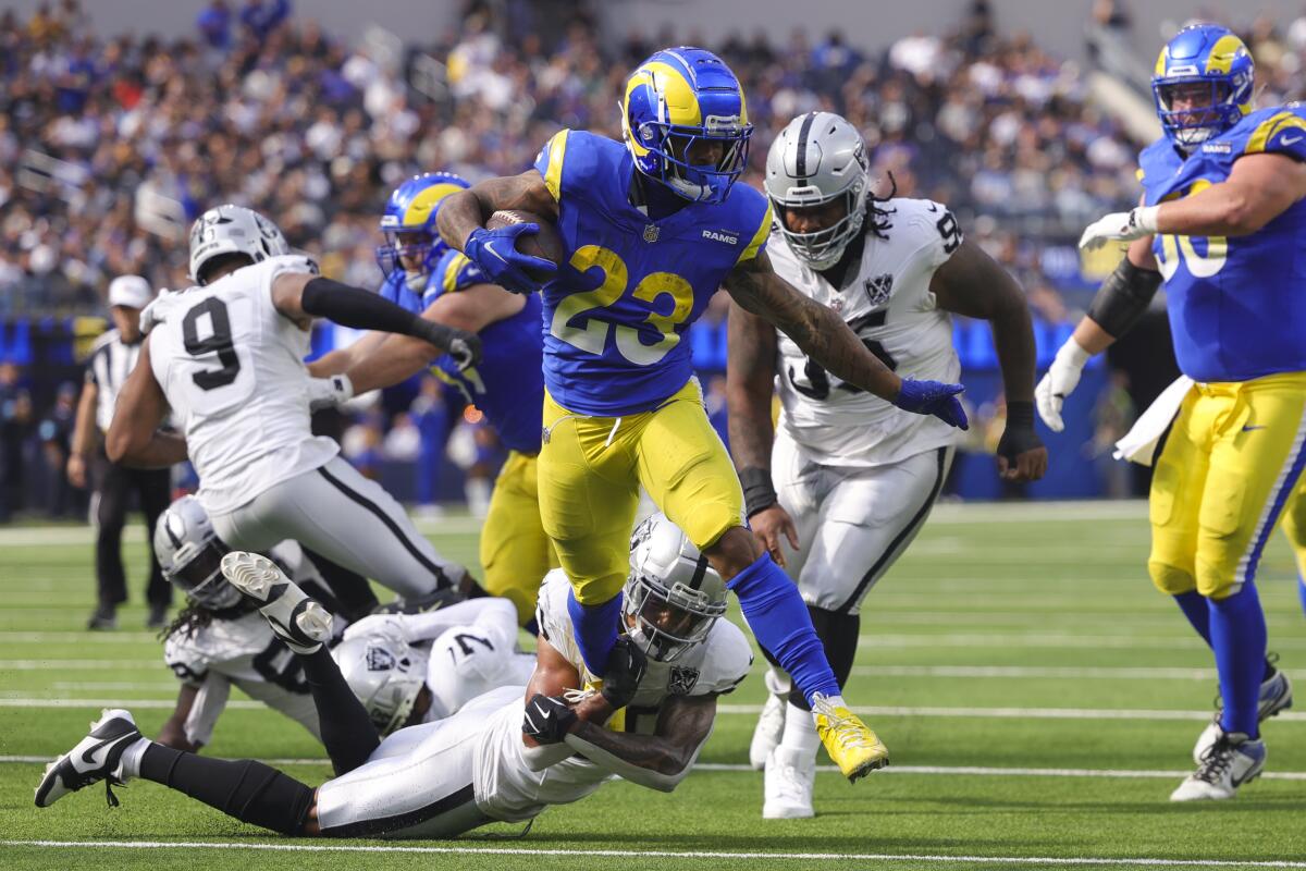 Kieren Williams (23) de Rams corre para un touchdown mientras el safety de Los Vegas Raiders, Isaiah Pola-Mao (abajo), intenta abordar.