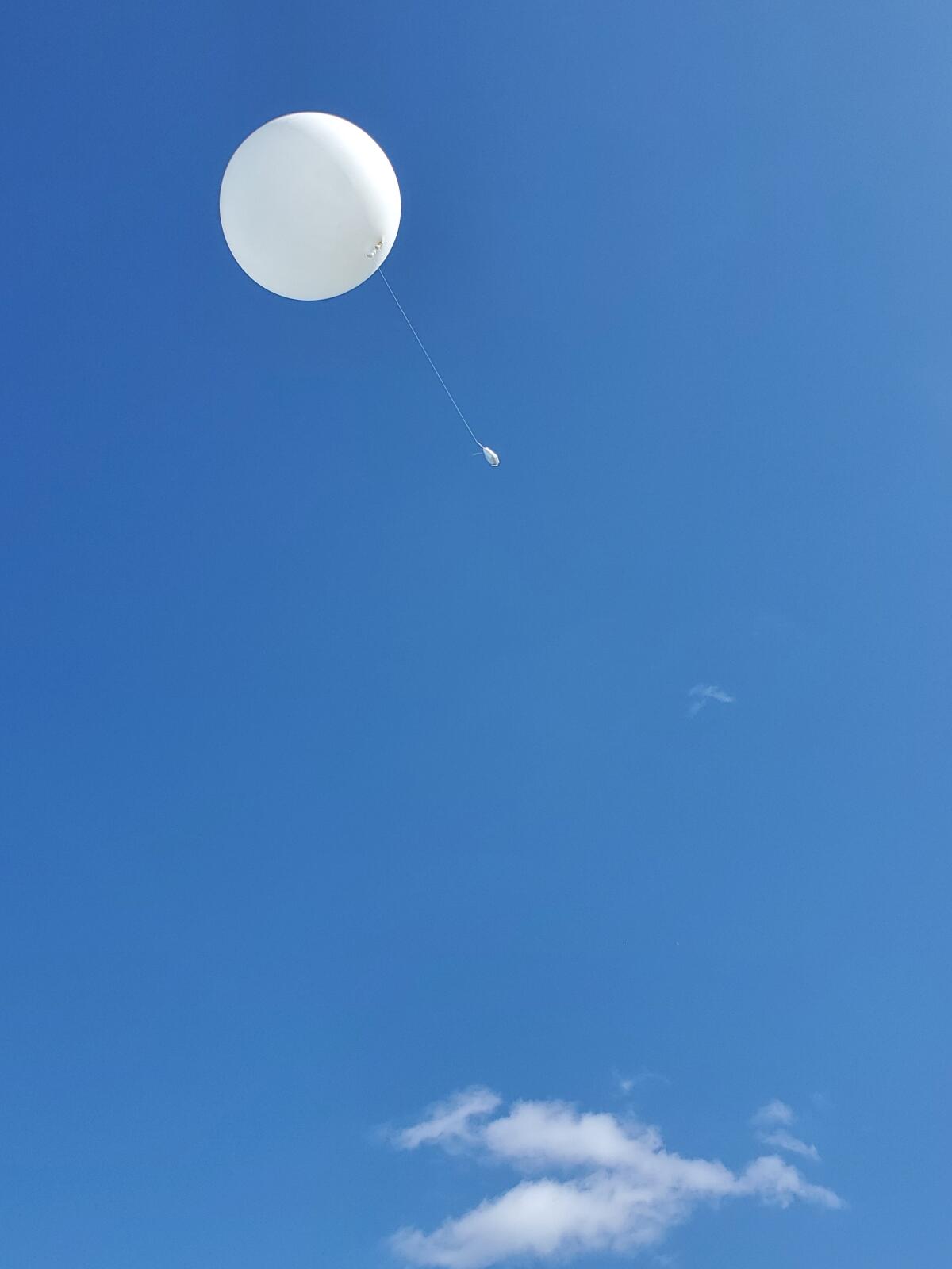 A weather balloon ascends over La Jolla on Feb. 13. It will send atmospheric information to instruments on Scripps Pier.