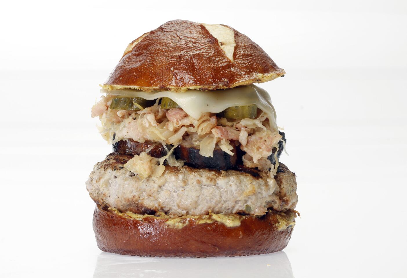 This bad boy stacks a bratwurst link atop a ground pork patty: German Cuban pork burger.