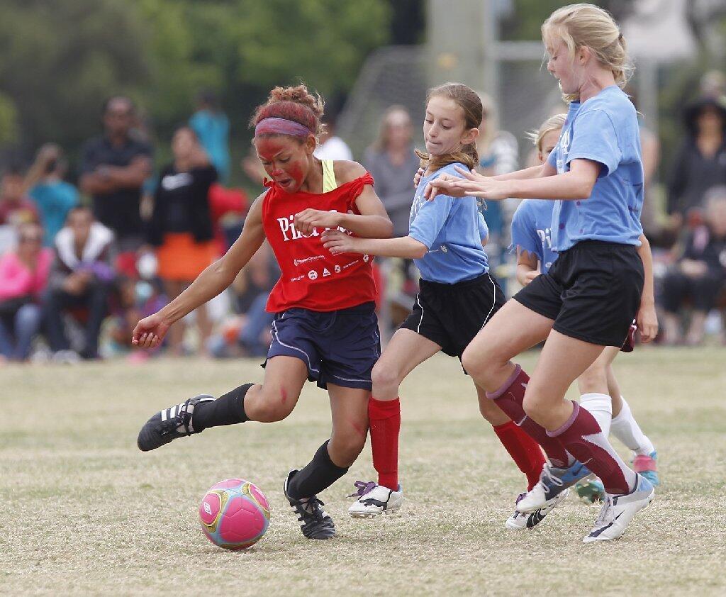 Kaiser's Trinity Rodman, far left, contols the ball at midfield as Andersen defenders move during the girls' 5-6 gold division championship game at the Pilot Cup Sunday.