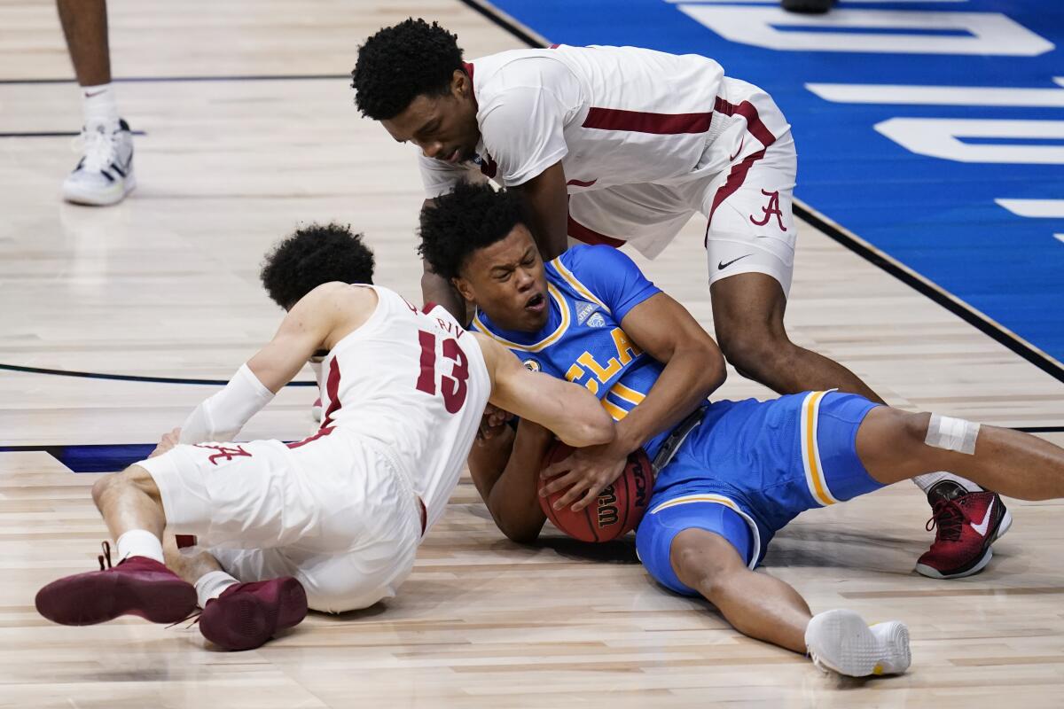 UCLA guard Jaylen Clark (0) and Alabama guard Jahvon Quinerly (13) battle for a loose ball, along with Herbert Jones (1).