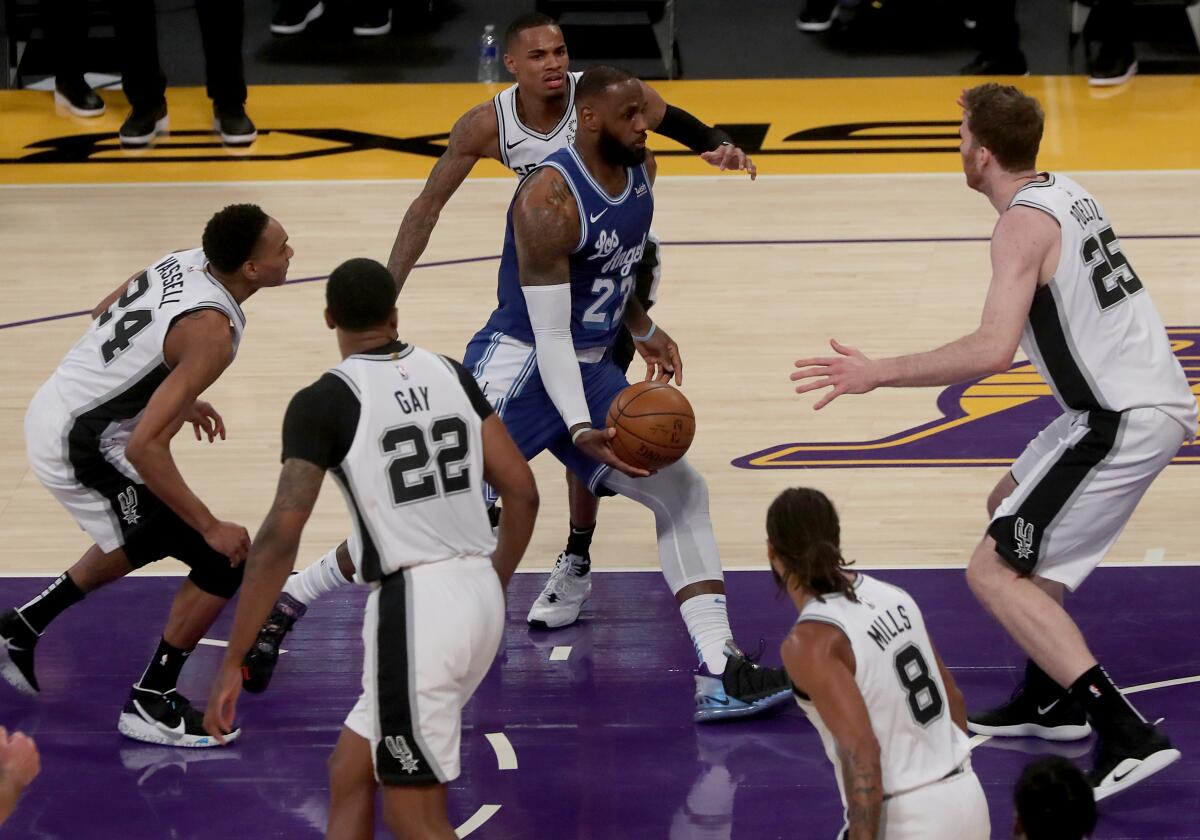 Lakers forward LeBron James draws the entire Spurs defense during a drive down the lane Thursday night.