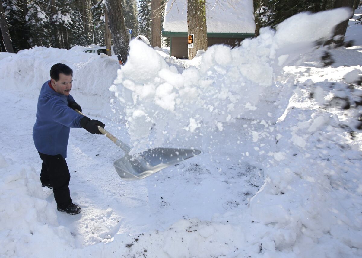 John Mamola shovels snow from the driveway leading to his cabin near Echo Summit, Calif., last month.