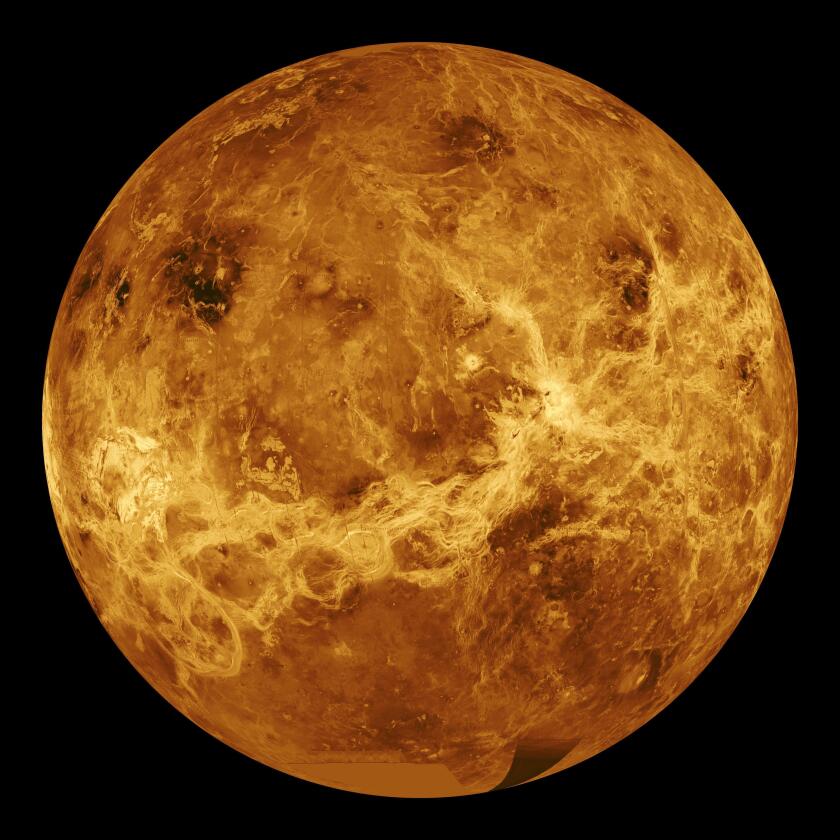 An orange and white image of Venus with swirls and craters