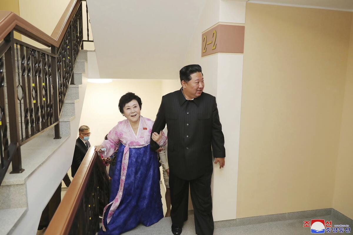 Kim Jong Un leads Ri Chun Hi up a flight of stairs.