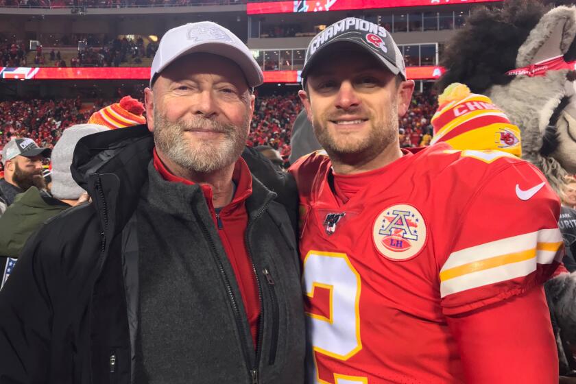 Craig Colquitt (left) and son, Dustin, enjoy a victorious moment after the Chiefs' AFC championship victory.