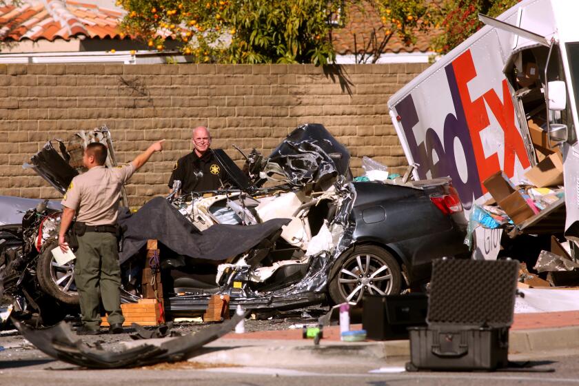 CERRITOS CA - JANUARY 5, 2022 - - Sheriff deputies investigate the scene of a six-vehicle crash involving a FedEx truck at the corner of Bloomfield Avenue and South Street in Cerritos on January 5, 2022. (Genaro Molina / Los Angeles Times)
