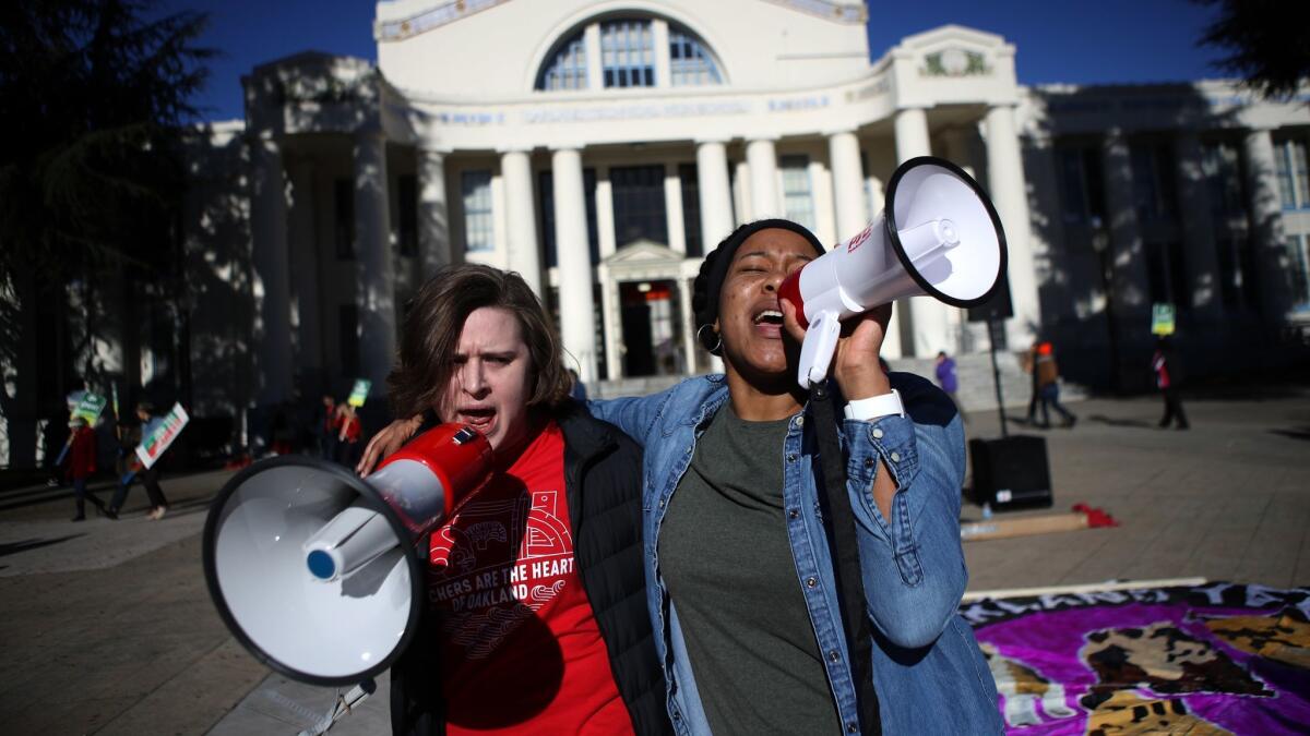 Oakland Unified School District teachers use bullhorns as they picket outside Oakland Technical High School.