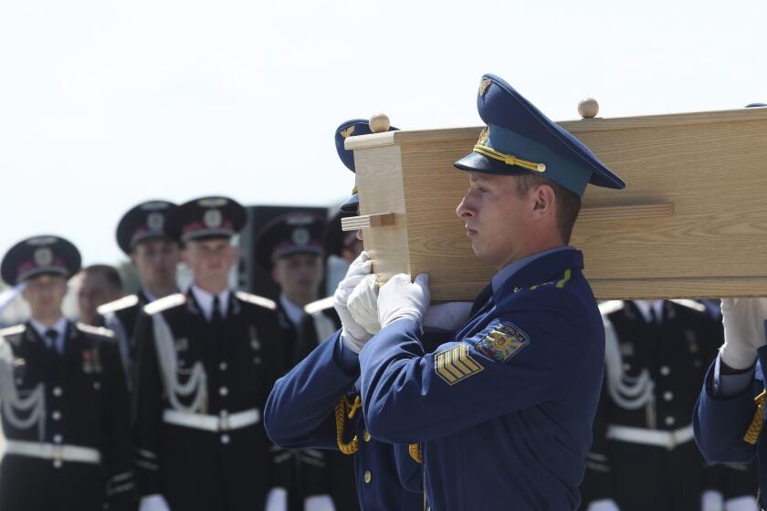A coffin with the remains of a victim of the Malaysia Airlines crash is loaded into a Dutch military plane during a ceremony at the airport in Kharkiv, Ukraine, on July 23.