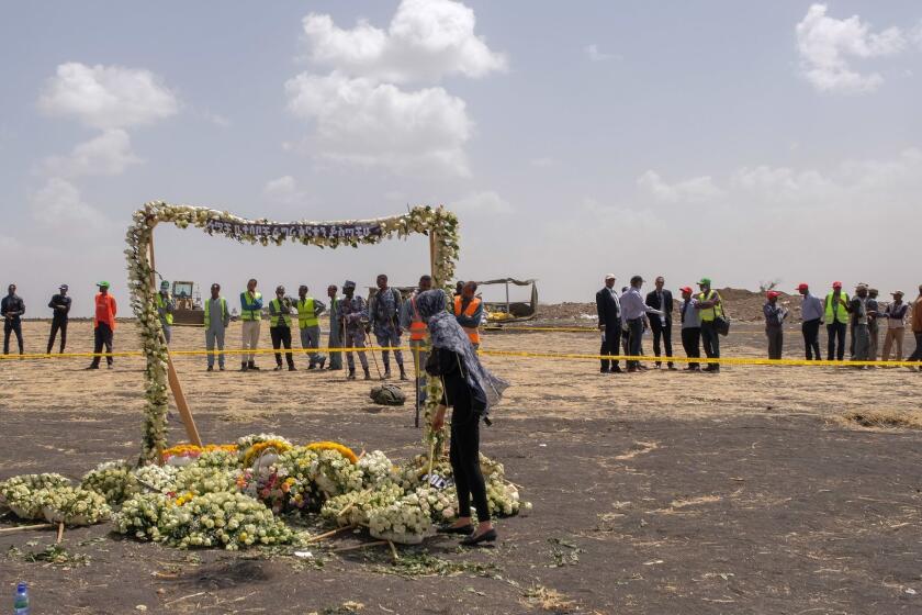 ADDIS ABABA, ETHIOPIA - MARCH 14: A mourner lays flowers at the Memorial Arch during a visit to the crash site of Ethiopian Airlines Flight ET302 on March 14, 2019 in Ejere, Ethiopia. All 157 passengers and crew perished after the Ethiopian Airlines Boeing 737 Max 8 Flight came down six minutes after taking off from Bole Airport. (Photo by Jemal Countess/Getty Images) ** OUTS - ELSENT, FPG, CM - OUTS * NM, PH, VA if sourced by CT, LA or MoD **