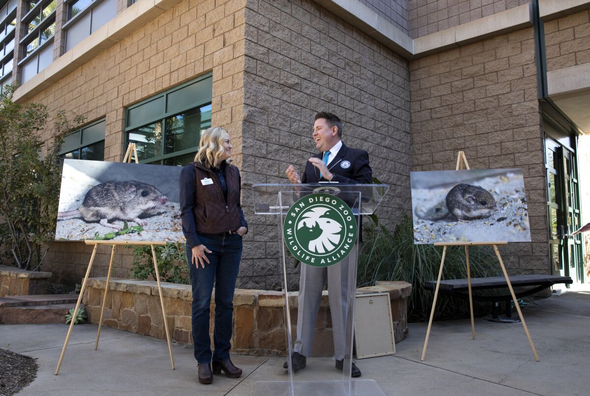 Debra Shier (left), receives a plaque that recognized Pat, a mouse in the park, as the oldest mouse in the world.
