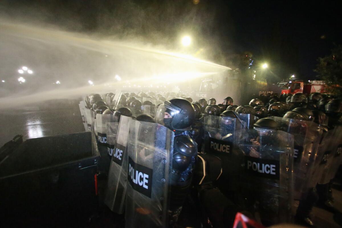 Georgia's police use water cannons to push back protesters trying to ...