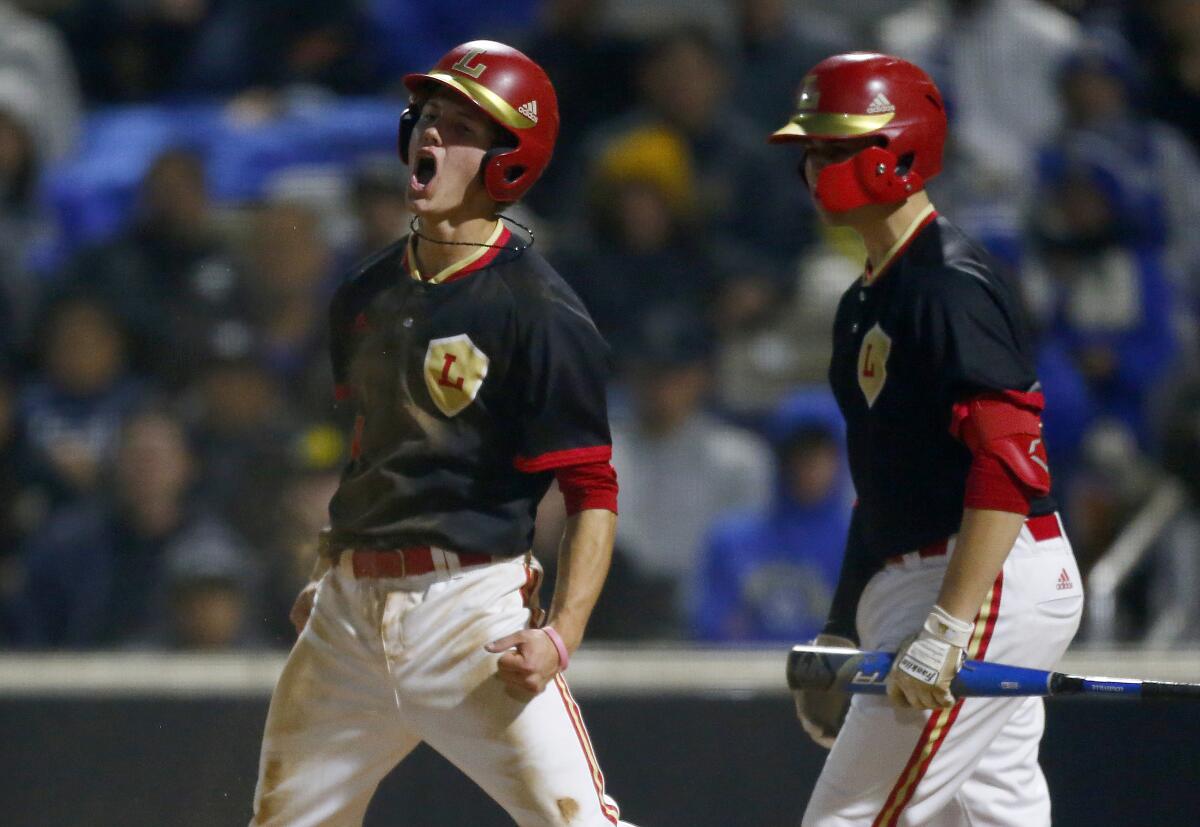 Orange Lutheran shortstop Justin DiCriscio, left, celebrates after scoring a run during a 2-0 victory over La Mirada at the Great Park Baseball Stadium in Irvine on Wednesday.