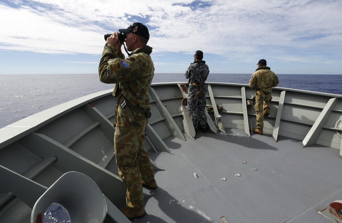 Australian Defense Force personnel aboard the Royal Australian Navy ship Perth search for debris from missing Malaysia Airlines Flight 370.