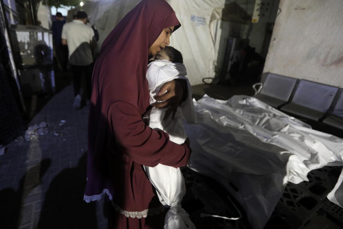 Una mujer palestina llora a un bebé de su familia, 