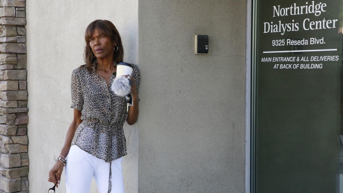 Dialysis patient Tangi Foster stands at the entrance to the clinic owned by U.S. Renal Care where she receives treatment several times a week.