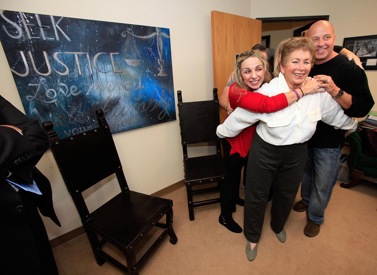 Stacy Thomas and Ron Thomas hug their aunt, Lois Goodman, on Nov. 30, 2012, shortly after her electronic monitoring device was removed. All charges against her were dropped earlier in the day.