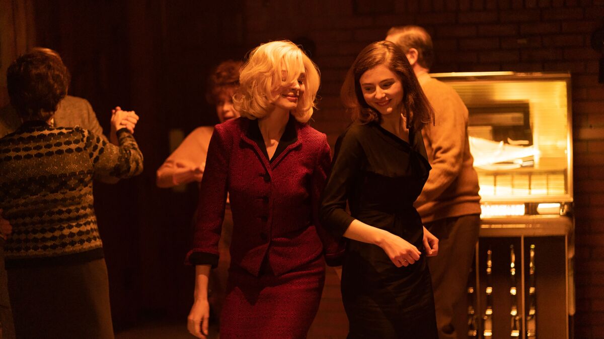 Anne Hathaway and Thomasin McKenzie dance in a bar in the movie "Eileen."