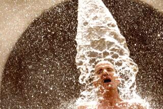 A man cools down in the splash pad area of the North Hollywood Pool 