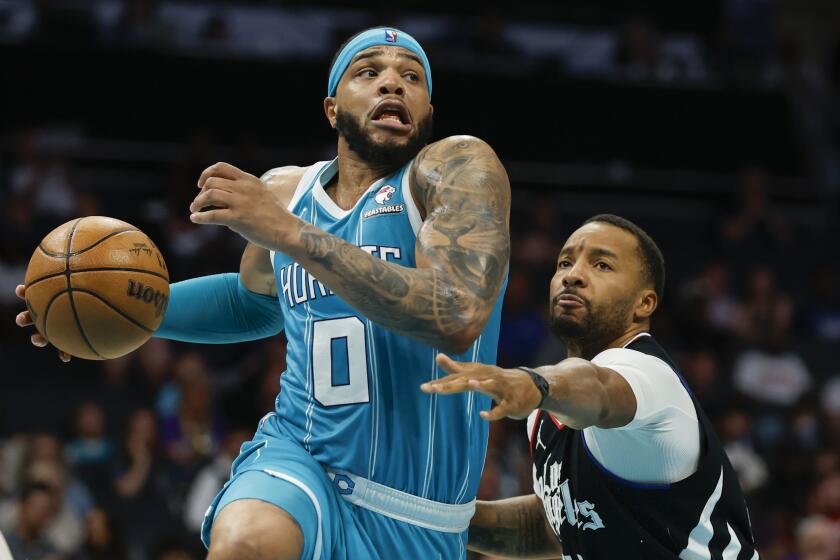 Charlotte Hornets forward Miles Bridges (0) drives against Los Angeles Clippers guard Norman Powell during the second half of an NBA basketball game in Charlotte, N.C., Sunday, March 31, 2024. (AP Photo/Nell Redmond)