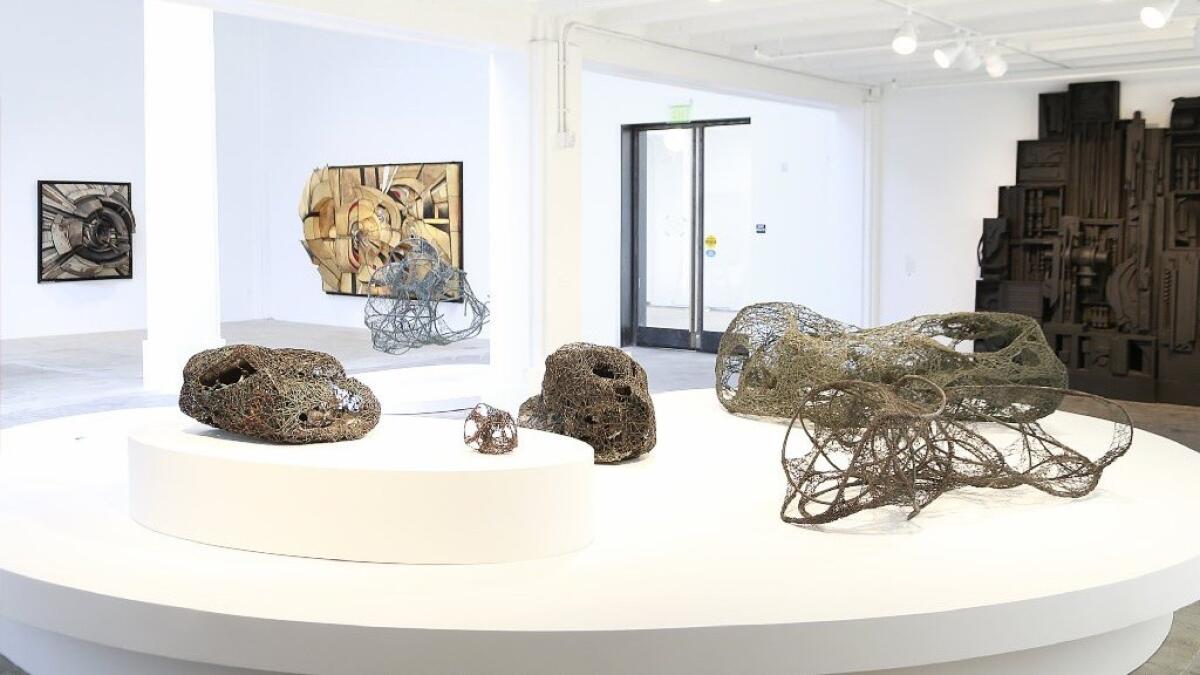 Claire Falkenstein sculptures, foreground, are shown with reliefs by Lee Bontecou, left rear, and Louise Nevelson, right rear, at Hauser Wirth & Schimmel.