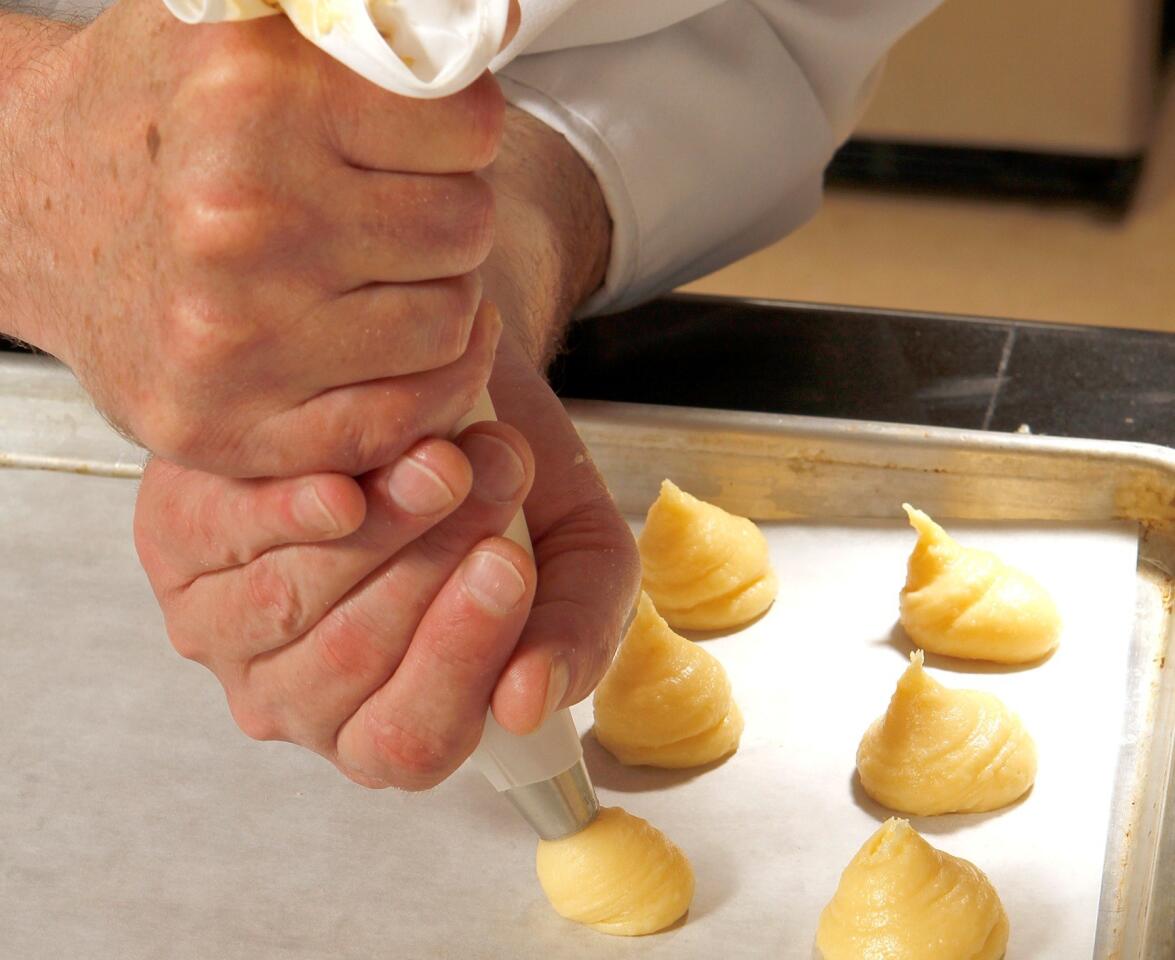 Pipe the gougeres paste out onto a lined baking sheet. You can either bake these now or freeze them for later.