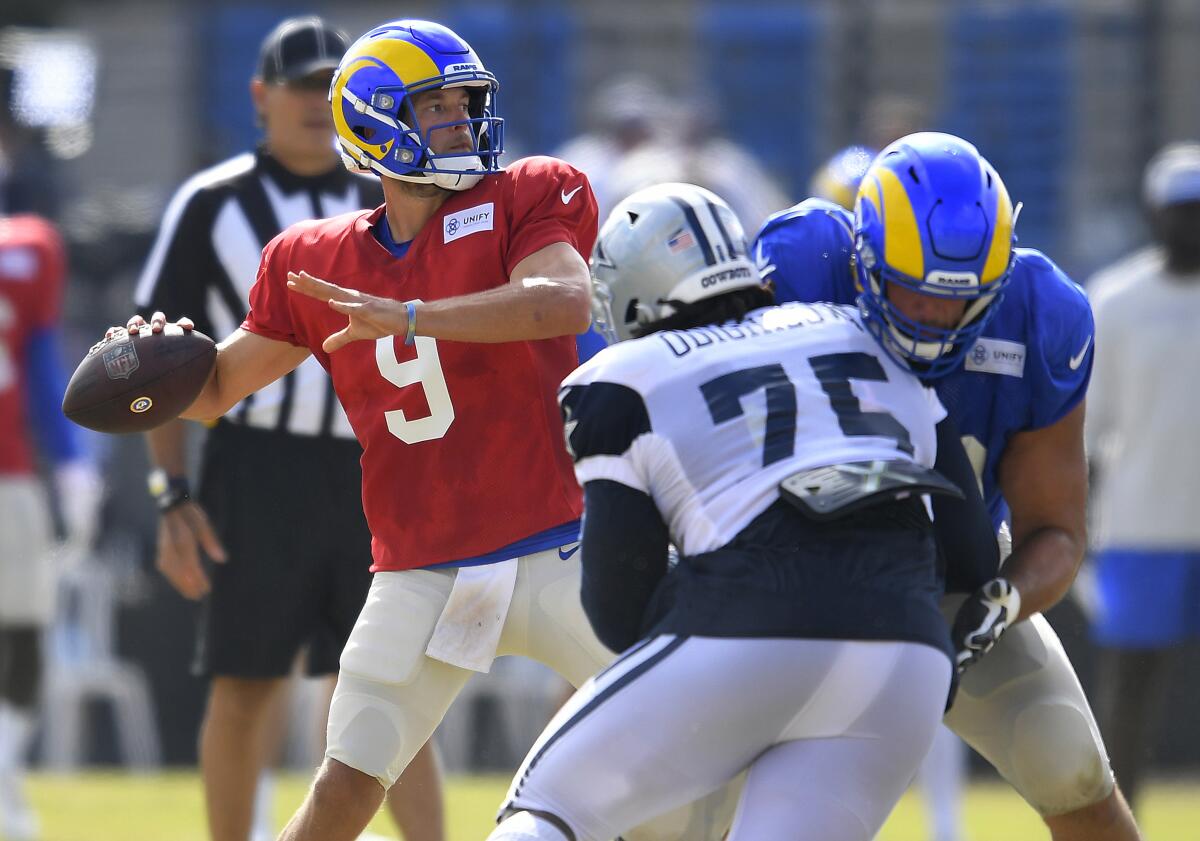 Rams quarterback Matthew Stafford looks for a receiver while the Dallas Cowboys' Osa Odighizuwa rushes.