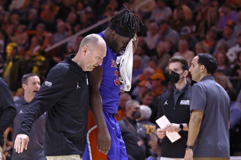 Florida center Jason Jitoboh (33) is lead from the court after being injured on a play during the first half of an NCAA college basketball game against Tennessee Wednesday, Jan. 26, 2022, in Knoxville, Tenn. (AP Photo/Wade Payne)