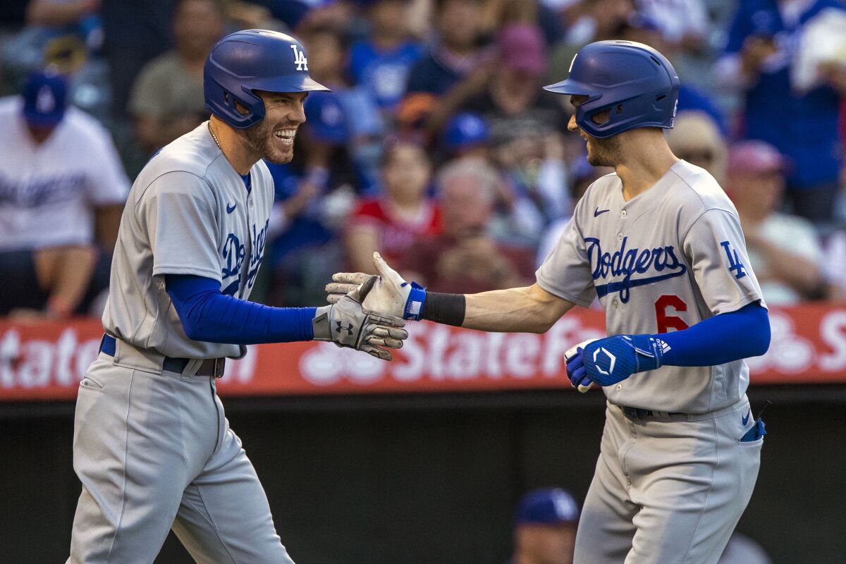 The Dodgers' Freddie Freeman slaps hands with Trea Turner.
