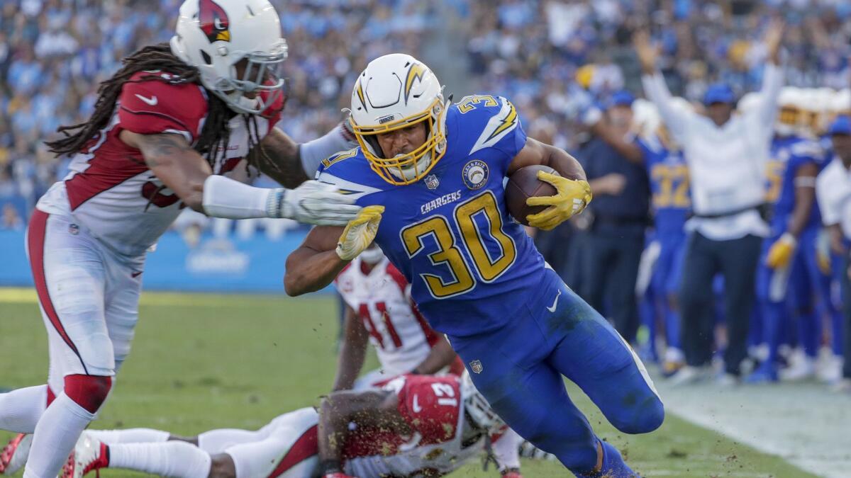 Chargers running back Austin Ekeler finishes a 13-yard run against the Cardinals.