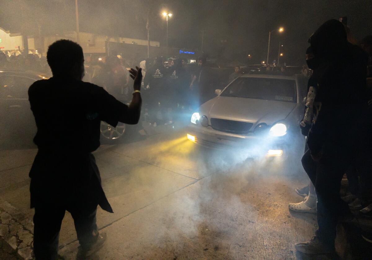 A person directing a car with its headlights on