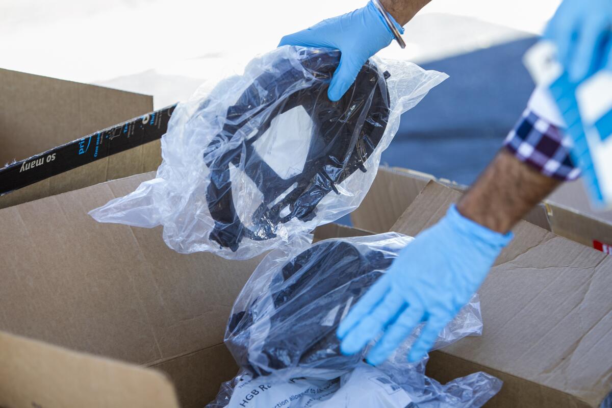 Jaspal Bassi, a first-year UC Irvine medical student, organizes face shields Monday during a drive to collect donated personal protective equipment for medical workers.