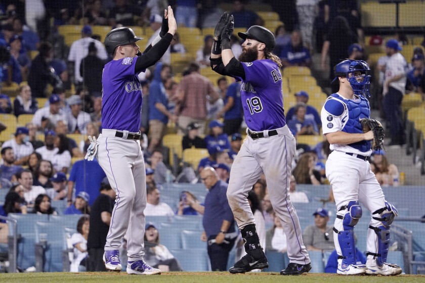 The Rockies' Charlie Blackmon, center, celebrates with Trevor Story after Blackmon hit a two-run homer in the 10th inning.