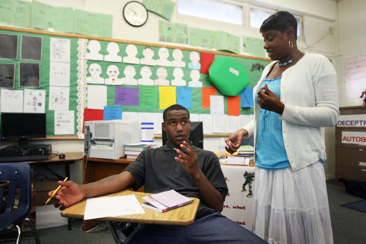 Marquis, 16, left, and English teacher Monica Jackson count the syllables in his haiku poem at Camp Afflerblaugh in La Verne. A new study found that California and other states were failing to adequately educate juvenile inmates but L.A. County court schools have made progress following a 2010 lawsuit.
