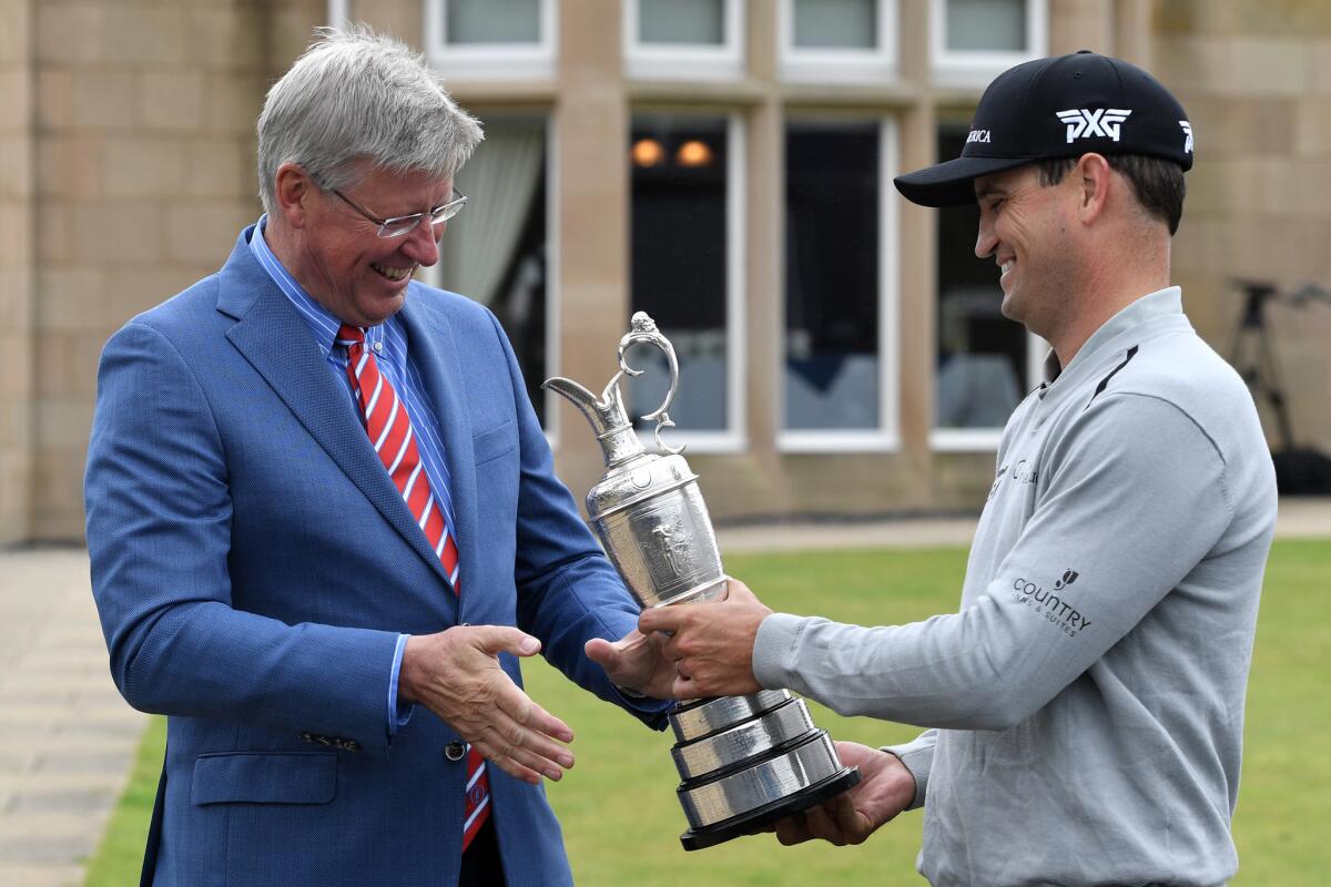 Defending British Open champion Zach Johnson hands over the Claret Jug to Martin Slumbers, Chief Executive of R&A, at Royal Troon on July 11 in Troon, Scotland.