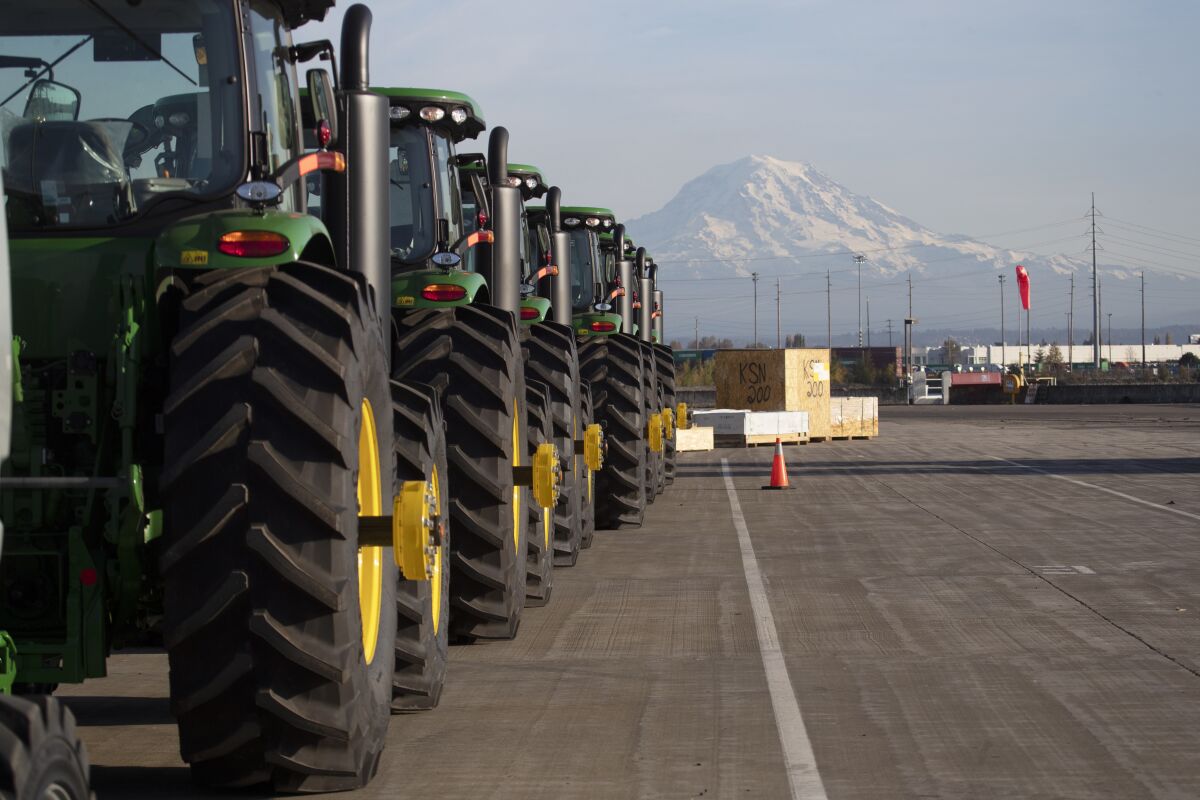 FILE - In this Nov. 4, 2019 file photo, John Deere tractors made by Deere & Company are shown as they are readied for export to Asia at the Port of Tacoma in Tacoma, Wash. The U.S. trade deficit fell in September 2020 after hitting a 14-year high in August as exports outpaced imports. The Commerce Department reported, Wednesday, Nov. 4, 2020, the gap between what the U.S. sells and what it buys abroad fell to 63.9 billion in September, a decline of 4.7% from a $67 billion deficit in August. (AP Photo/Ted S. Warren, File)