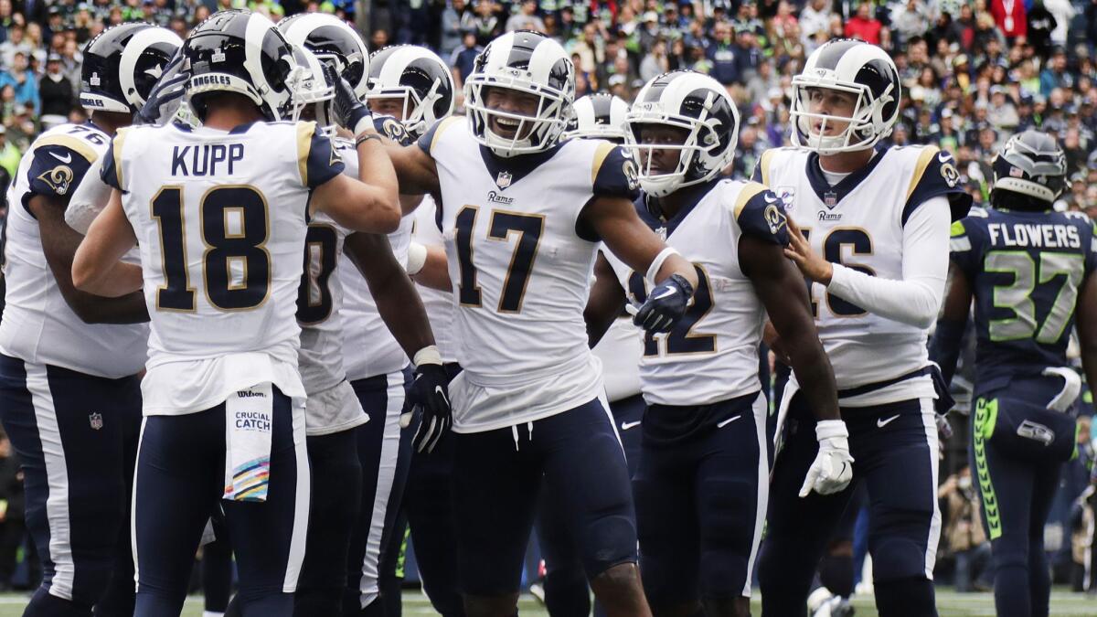 Rams wide receivers Cooper Kupp (18), Robert Woods (17), Brandin Cooks (12) and quarterback Jared Goff (16) surround running back Todd Gurley (30) after a touchdown against the Seattle Seahawks on Sunday.