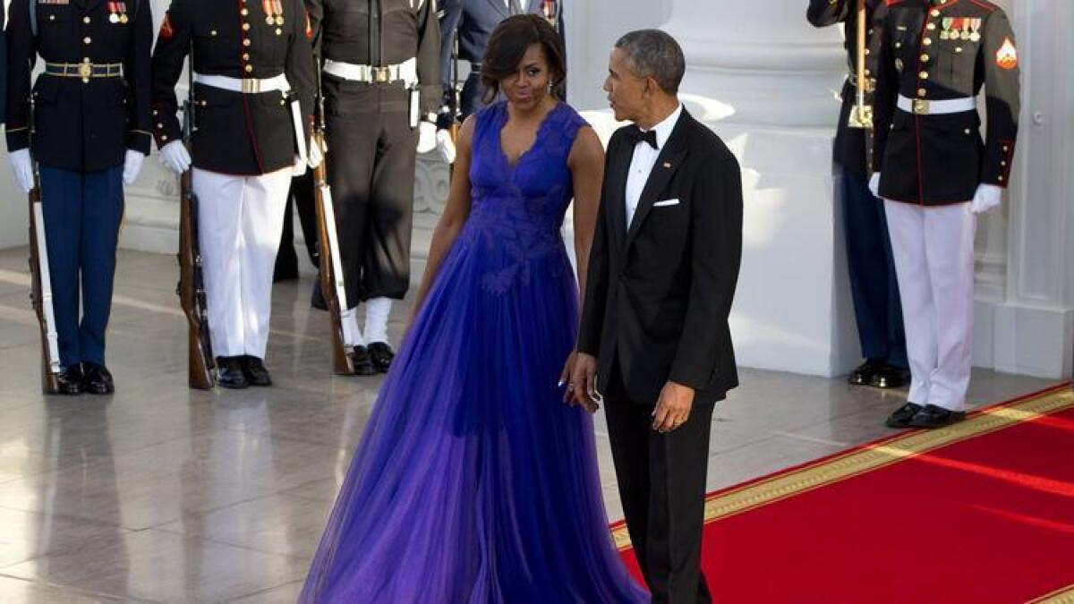 First Lady Michelle Obama wears a Tadashi Shoji gown as she and President Obama arrive at a state dinner in April.