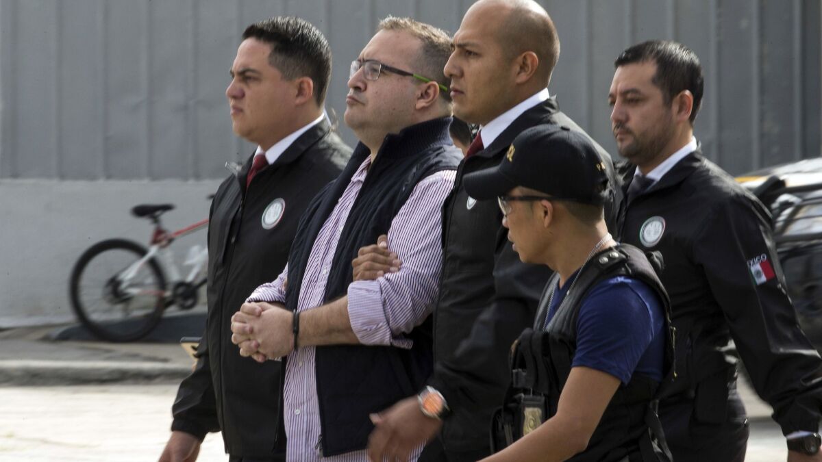Mexico's former governor of Veracruz state, Javier Duarte, is escorted in handcuffs by police to an aircraft in 2017 as he is extradited to Mexico City