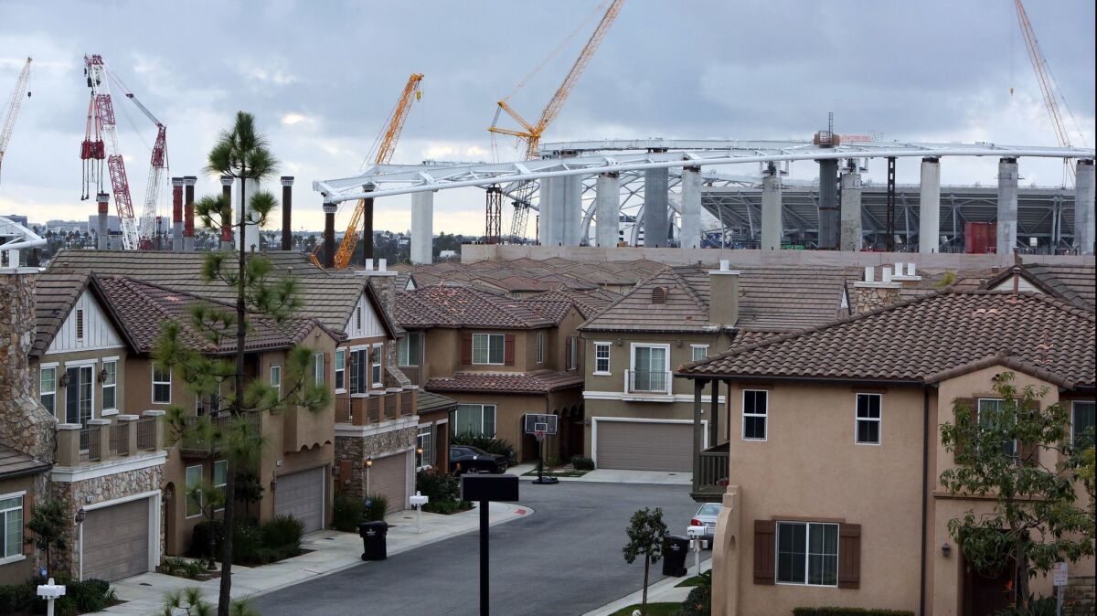 Construction of the Rams-Chargers Complex is seen behind the Renaissance Homes in Inglewood on Feb. 20.