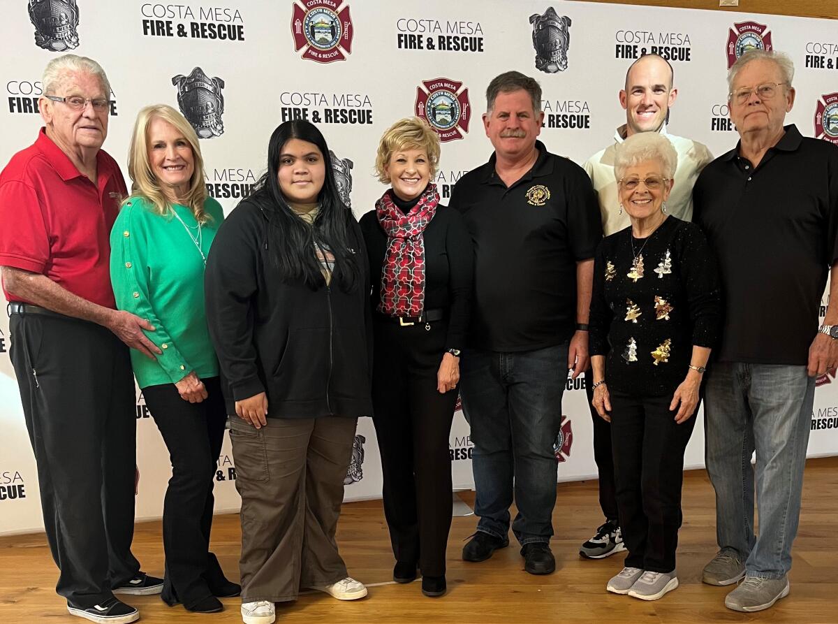 Brenda Emrick, center, poses with family members at a December meeting of the Costa Mesa Fire Department.