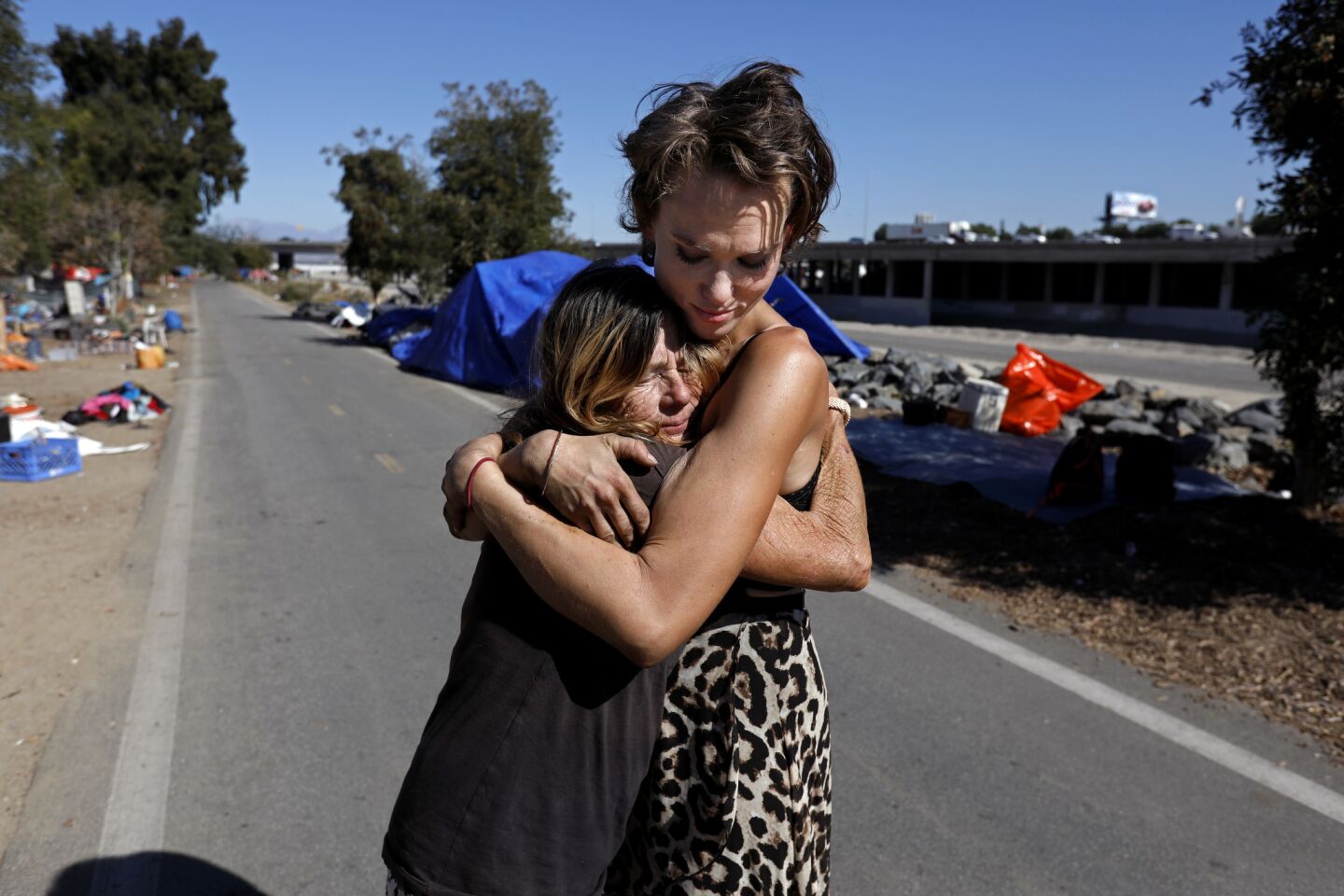 Kathy Schuler, 62, left, who was released from jail Tuesday evening, is given a hug by her granddaughter Ashley Foster, 23, where they live at a homeless encampment along the Santa Ana River in Anaheim.